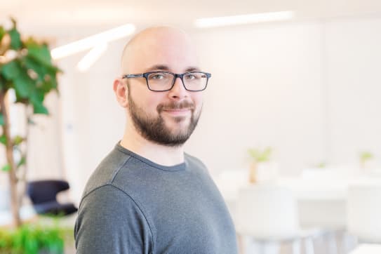 Shopware employee smiling towards the camera.